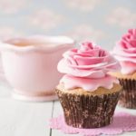 Cupcakes with sweet rose flowers and a cup of tee